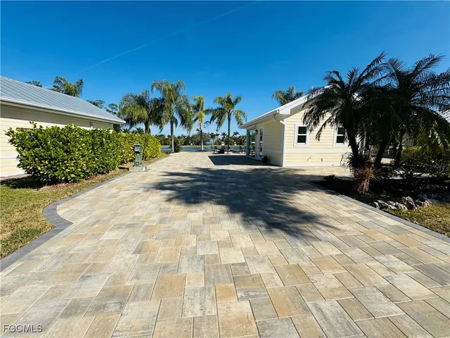 a view of a white house with a yard and potted plants