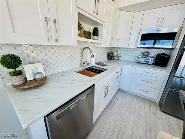 a kitchen with stainless steel appliances granite countertop a sink dishwasher stove and microwave with wooden cabinets