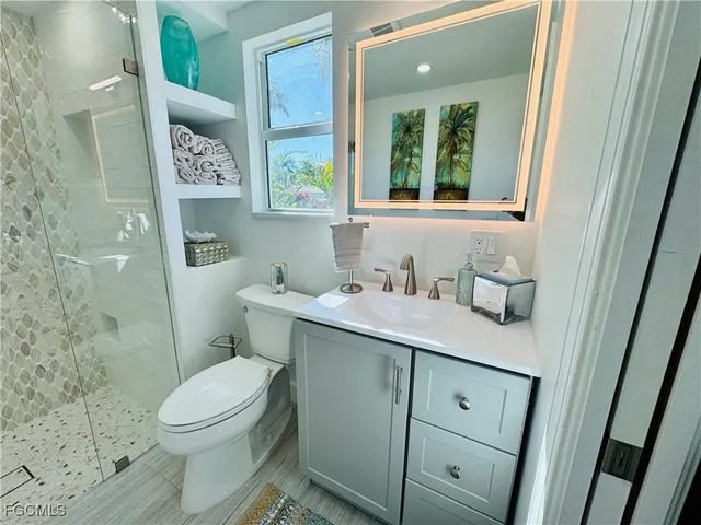 a bathroom with a granite countertop toilet sink and mirror