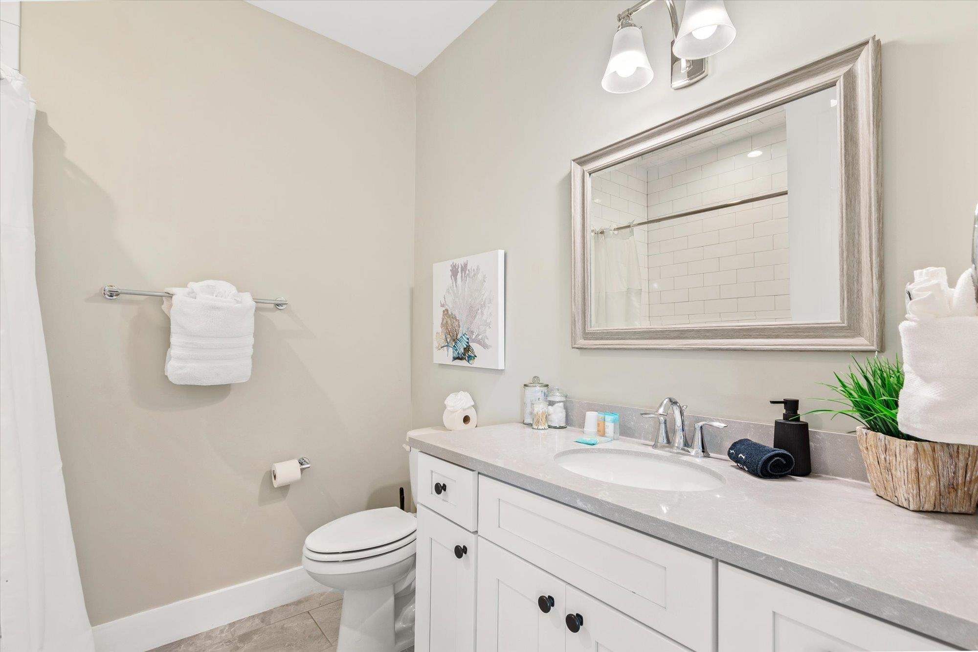 80 Ferrol Road St. Augustine, FL 32084 - Photo 32 of 61 a bathroom with a granite countertop sink a toilet and mirror