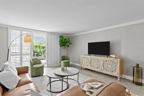 a living room with furniture a flat screen tv and a large window