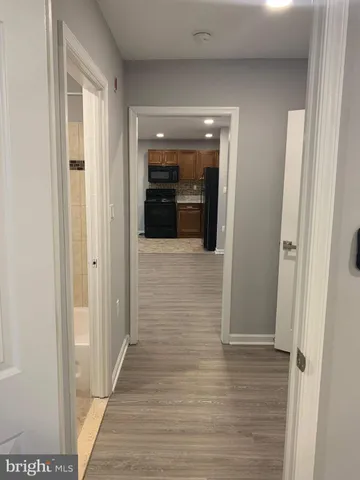 a view of a hallway with wooden floor and staircase