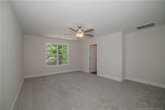 an empty room with a window and a ceiling fan