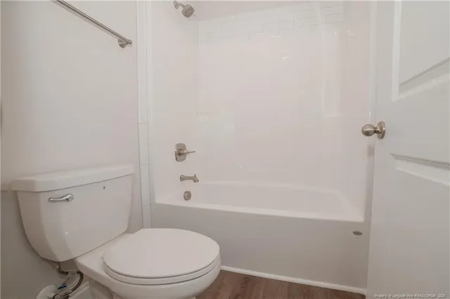 a white toilet sitting next to a bath tub