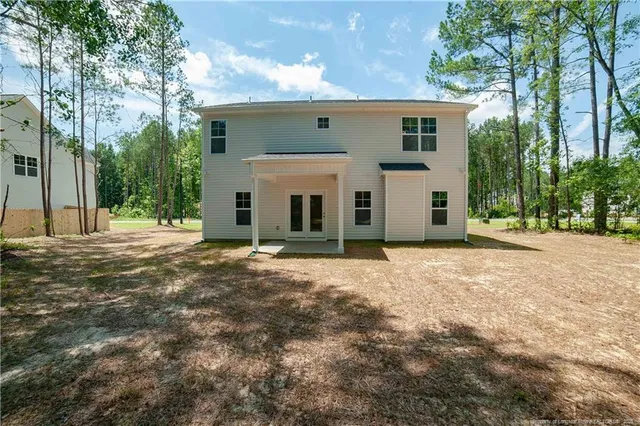 a view of a house with backyard and trees
