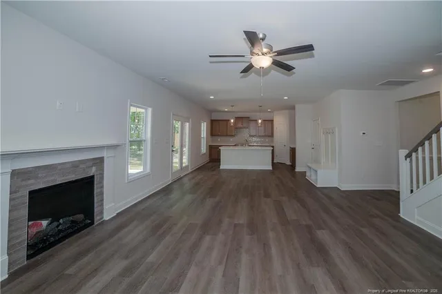 a view of empty room with wooden floor and fireplace
