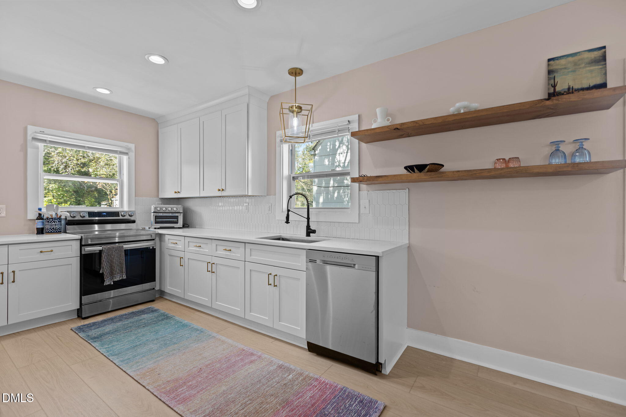 2707 North Roxboro Street Durham, NC 27704 - Photo 18 of 44 a kitchen with stainless steel appliances granite countertop a sink dishwasher a stove and white cabinets with wooden floor