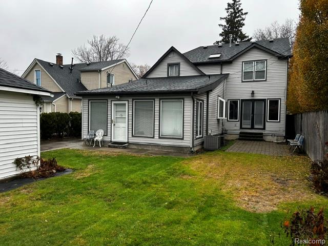 89 Muir Road Grosse Pointe, MI 48236 - Photo 2 of 29 Rear exterior with a pitched roof, multiple windows, and a paved patio area