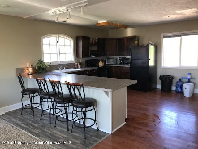 520 Elm Court Rifle, CO 81650 - Photo 28 of 37 a kitchen with granite countertop a table chairs stove and cabinets