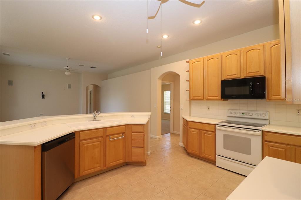 605 Cheviot Court Apopka, FL 32712 - Photo 7 of 32 a kitchen with stainless steel appliances granite countertop a sink and a stove