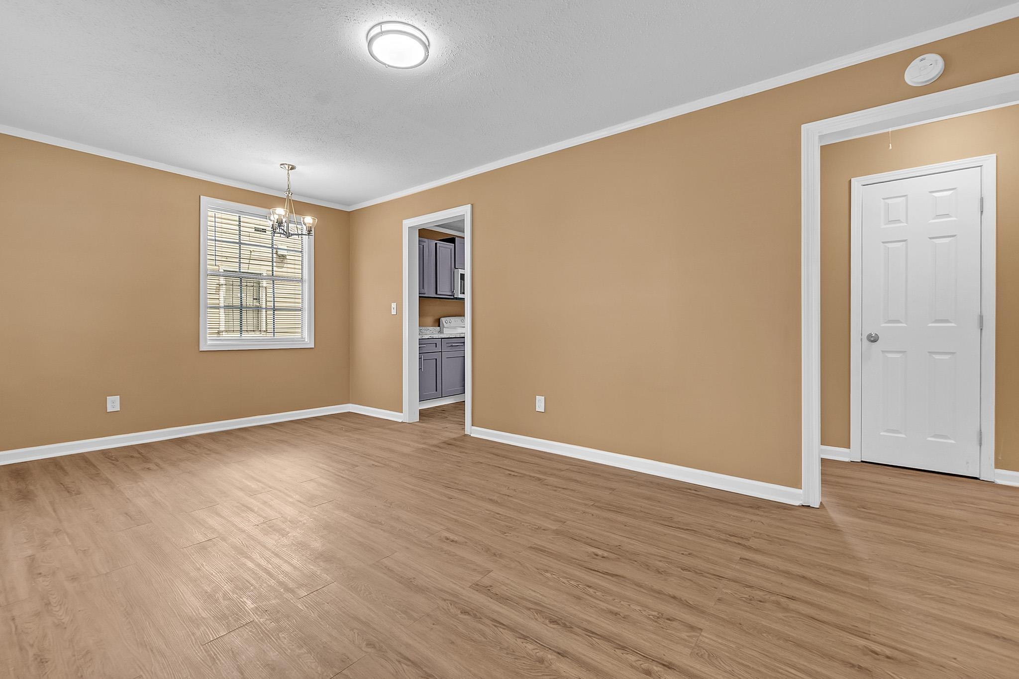 3186 Alta Road Memphis, TN 38109 - Photo 4 of 17 an empty room with wooden floor and windows