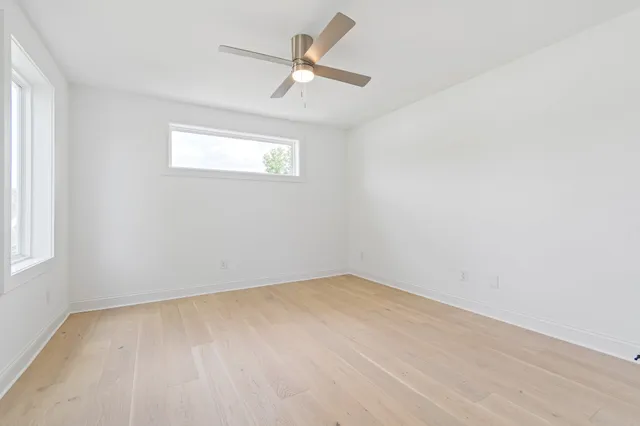 an empty room with a window and a fan