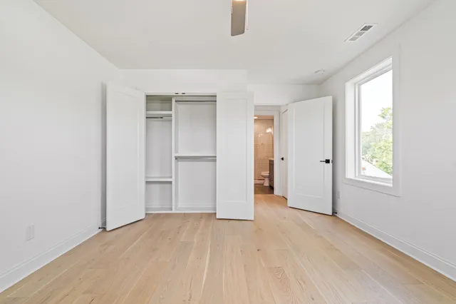 an empty room with windows and closet