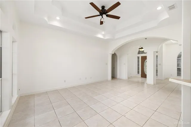 an empty room with closet and a ceiling fan