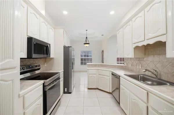 a kitchen with a sink stove top oven and cabinets