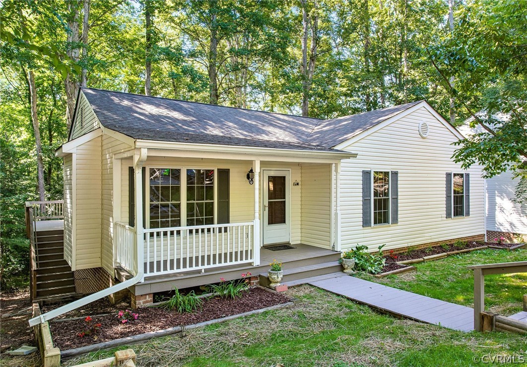 a porch with a bench next to a yard