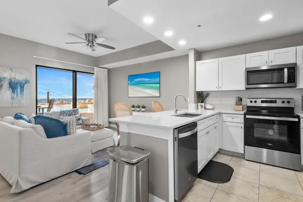a living room with stainless steel appliances granite countertop a couch and a view of living room