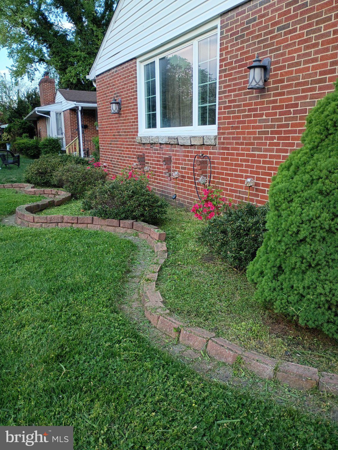 6723 Collinsdale Road Baltimore, MD 21234 - Photo 40 of 43 Charming brick facade with lush greenery.