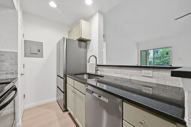 a kitchen with stainless steel appliances a sink and a refrigerator