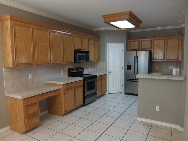 a kitchen with a sink a counter top space cabinets and stainless steel appliances