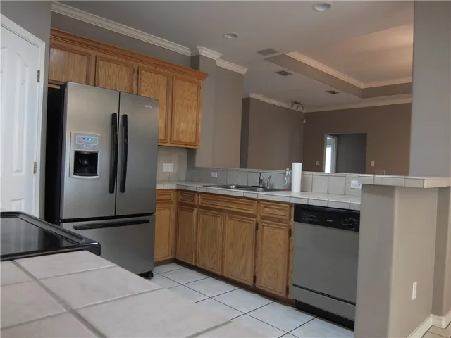 a kitchen with stainless steel appliances granite countertop a refrigerator and a sink