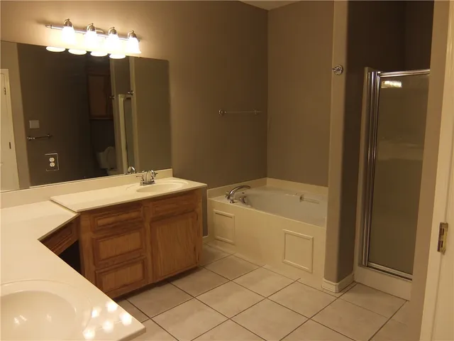 a bathroom with a double vanity sink a mirror and a bathtub