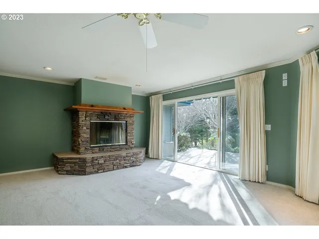 a living room with a fireplace and a floor to ceiling window