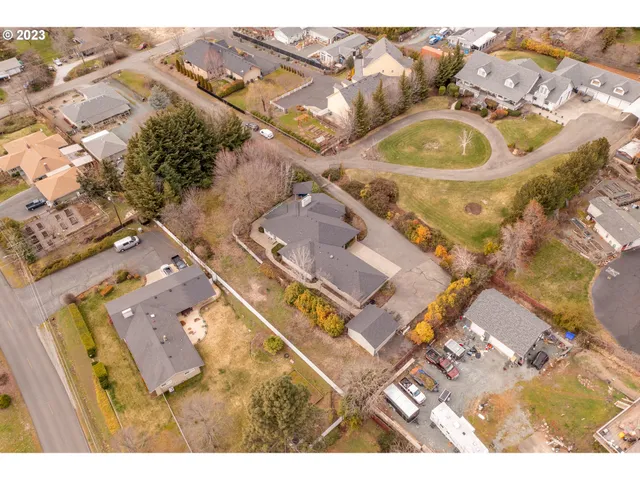 an aerial view of a house with garden space and a car