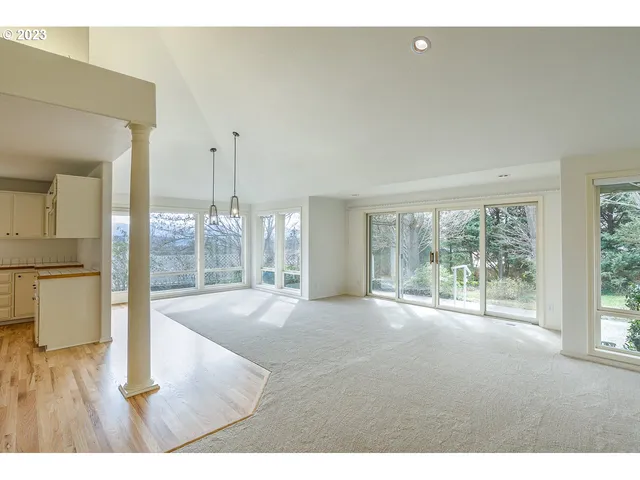 a big room with wooden floor and windows