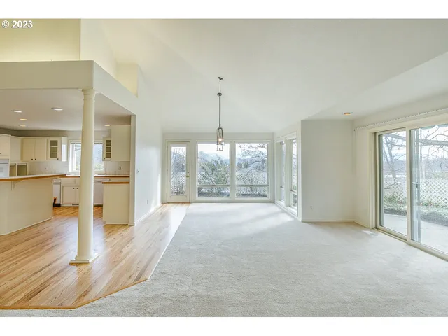a big room with wooden floor and windows