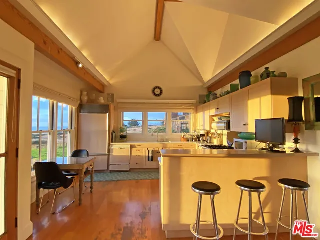 a living room with stainless steel appliances kitchen island granite countertop furniture and a flat screen tv
