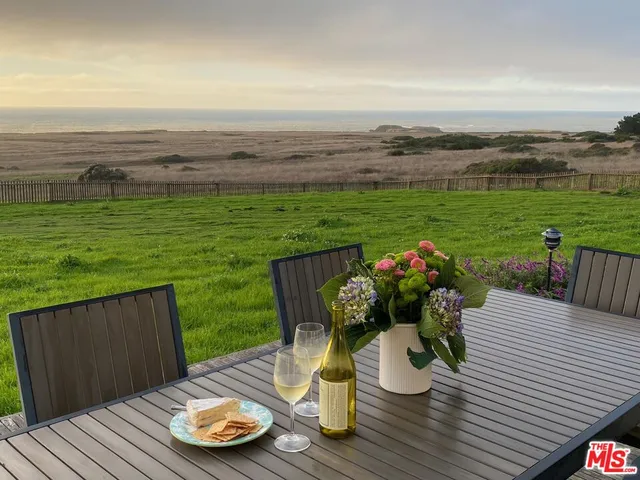 a bedroom with a bed a large window and wooden floor