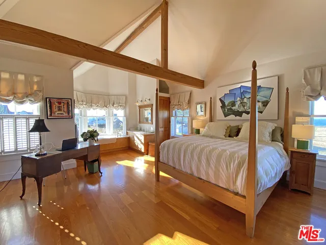 a bedroom with a large bed and a chandelier