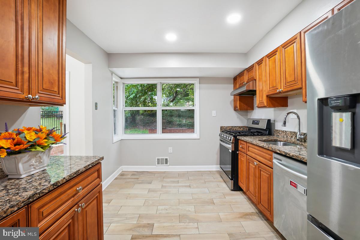 10307 Leslie Street Silver Spring, MD 20902 - Photo 13 of 46 a kitchen with stainless steel appliances granite countertop a sink stove and refrigerator