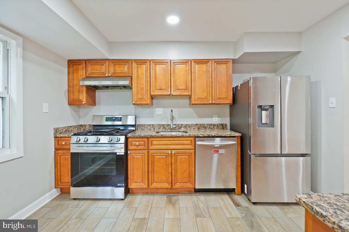 10307 Leslie Street Silver Spring, MD 20902 - Photo 16 of 46 a kitchen with stainless steel appliances granite countertop a stove a refrigerator and a stove