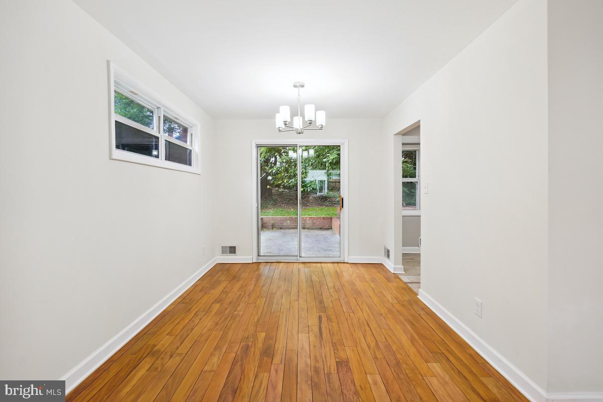 10307 Leslie Street Silver Spring, MD 20902 - Photo 10 of 46 an empty room with wooden floor chandelier and windows