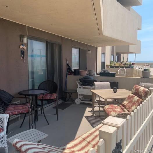 360 Shore Road, Unit 2H Long Beach, NY 11561 - Photo 12 of 13 View of patio featuring outdoor dining area and a water view