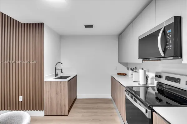 a kitchen with stainless steel appliances granite countertop a sink stove and microwave