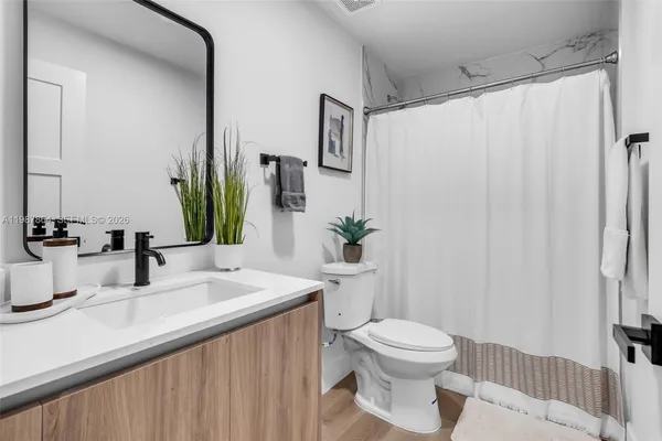 a bathroom with a sink a toilet and shower