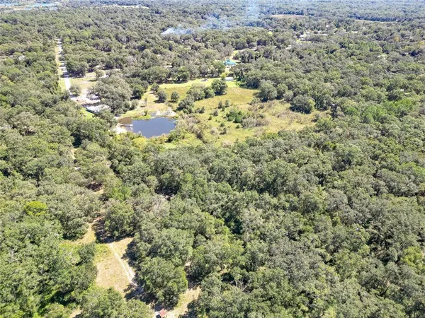 a view of dirt field with trees in the background