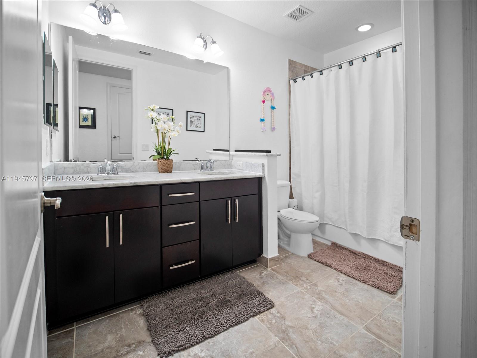 10552 Belfry Circle Orlando, FL 32832 - Photo 17 of 32 a spacious bathroom with a granite countertop sink a toilet and a mirror