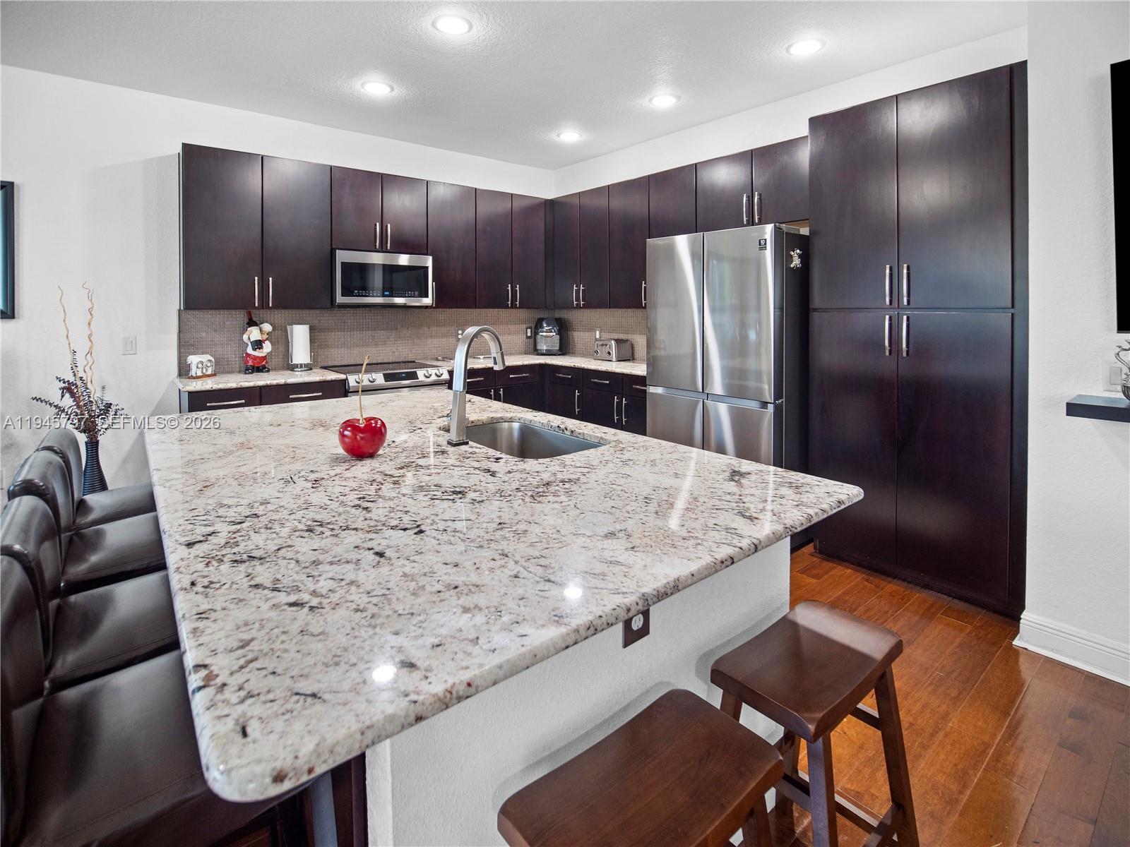 10552 Belfry Circle Orlando, FL 32832 - Photo 7 of 32 a kitchen with stainless steel appliances granite countertop a sink refrigerator and cabinets
