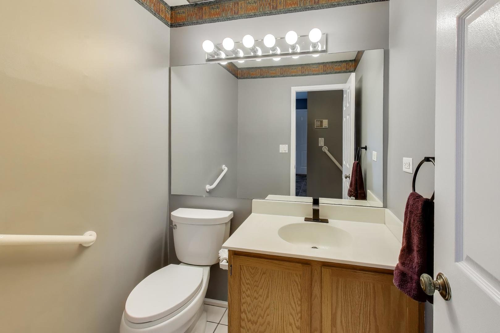 1096 Pine Tree Circle North Buffalo Grove, IL 60089 - Photo 22 of 25 a bathroom with a sink a toilet and mirror