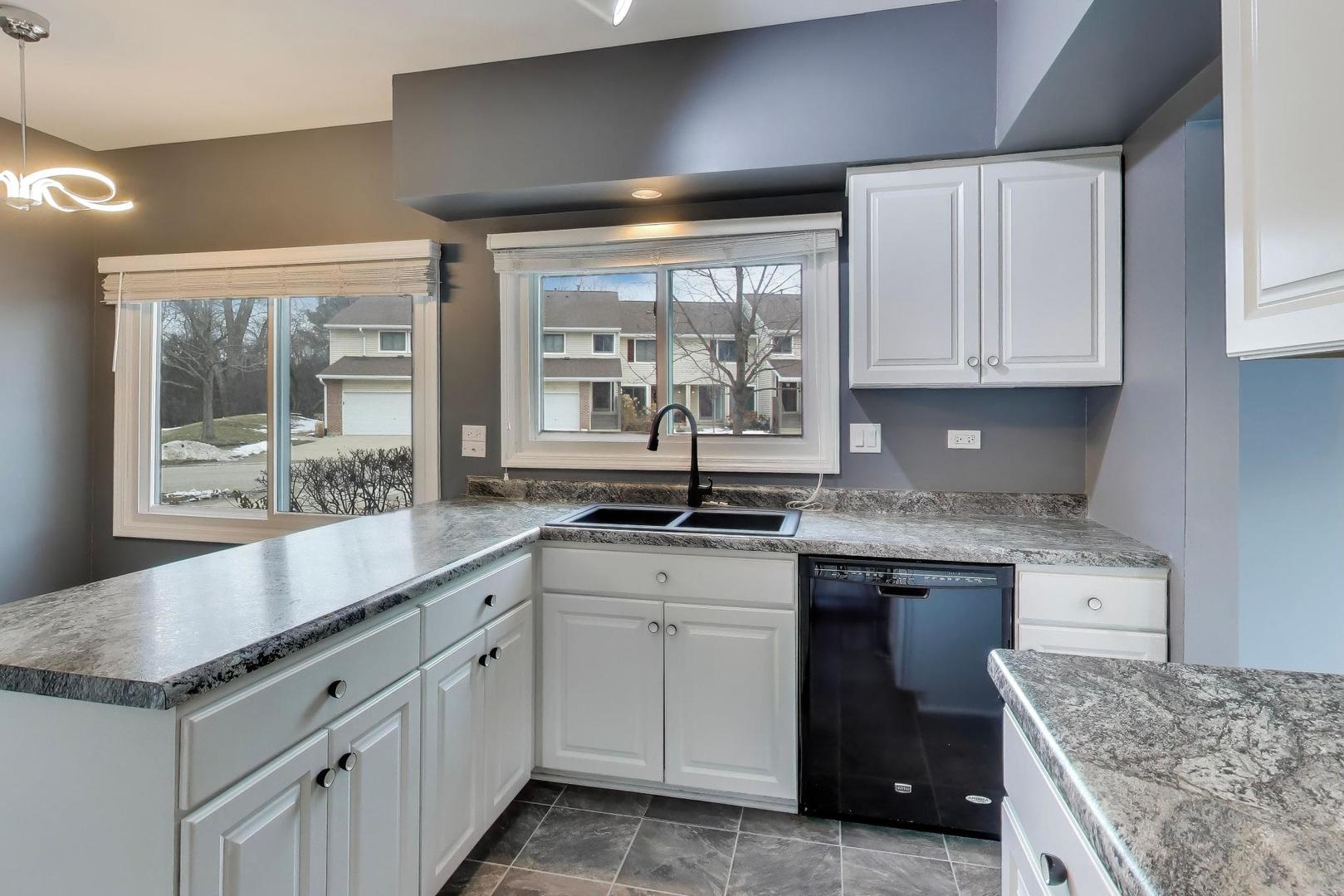 1096 Pine Tree Circle North Buffalo Grove, IL 60089 - Photo 8 of 25 a kitchen with granite countertop a sink stove and cabinets