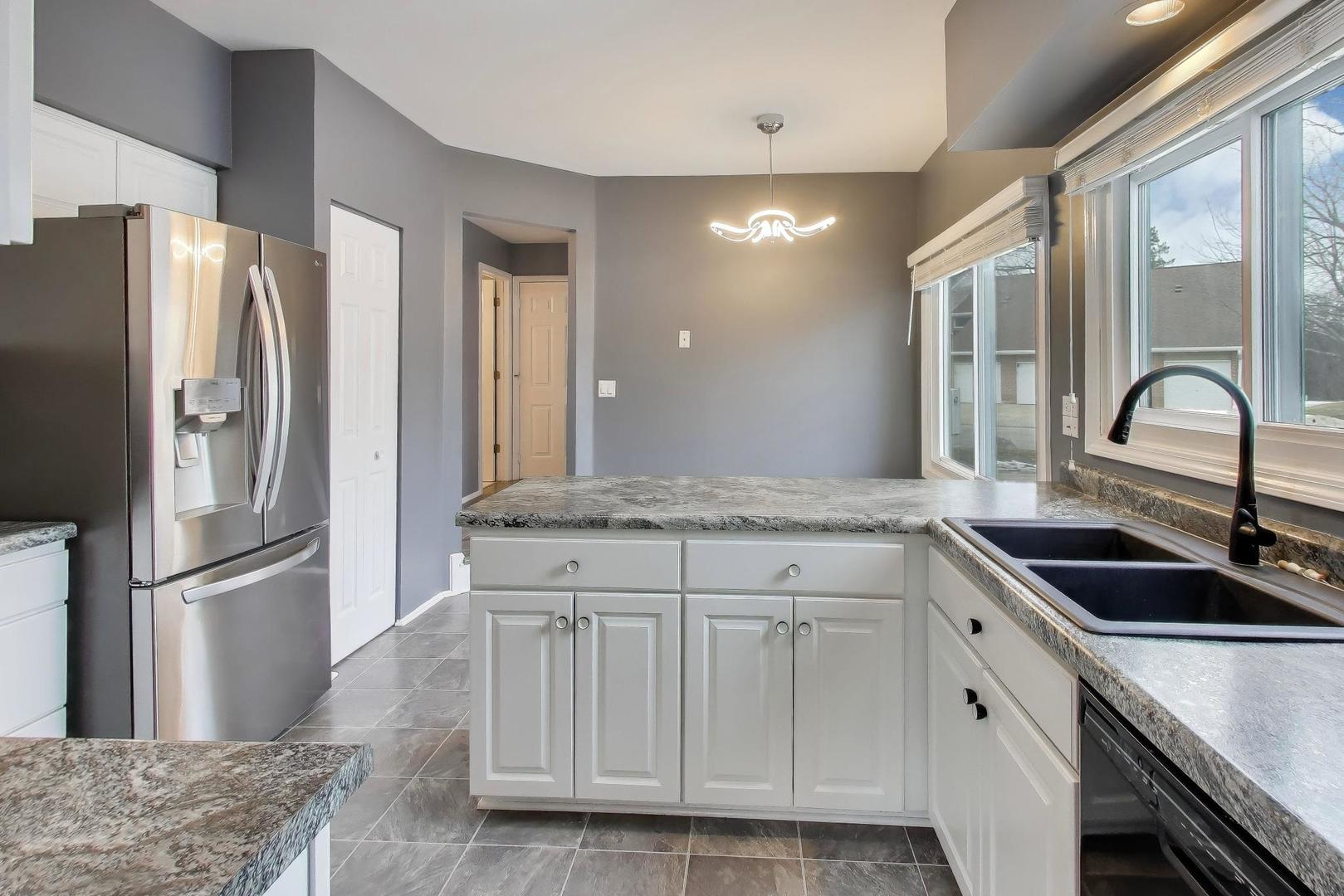 1096 Pine Tree Circle North Buffalo Grove, IL 60089 - Photo 9 of 25 a kitchen with granite countertop a sink and refrigerator