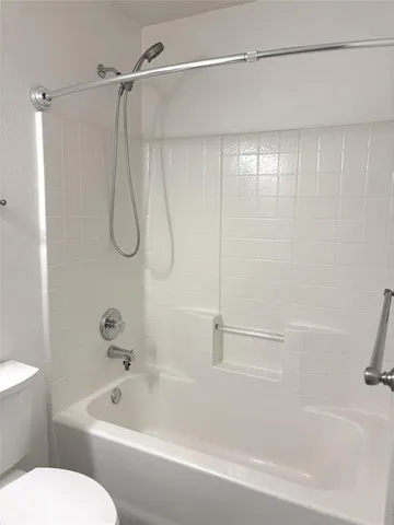a bathroom with a shower and a white bath tub