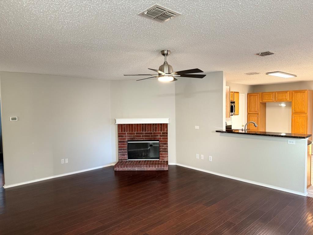 8201 Canoe Ridge Lane Denton, TX 76210 - Photo 3 of 25 an empty room with wooden floor a ceiling fan and windows
