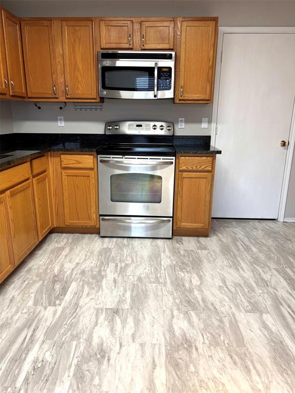 8201 Canoe Ridge Lane Denton, TX 76210 - Photo 8 of 25 a kitchen with granite countertop a stove and a microwave oven