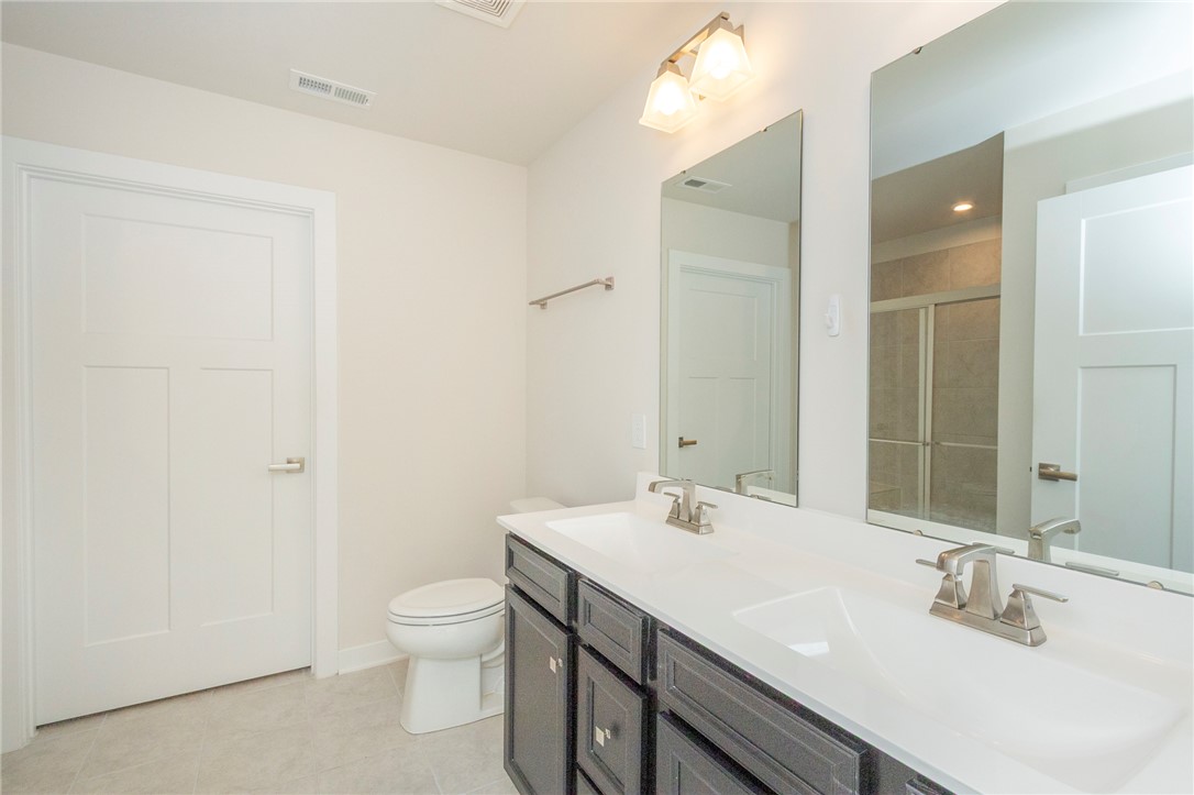233 Scenic Road Anderson, SC 29621 - Photo 30 of 50 A well-appointed bath features a double vanity and a glass-enclosed shower, offering comfort and convenience.