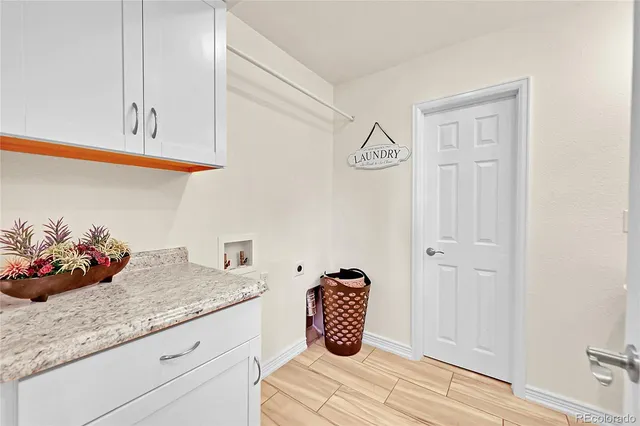 a room with granite countertop white cabinets and a potted plant